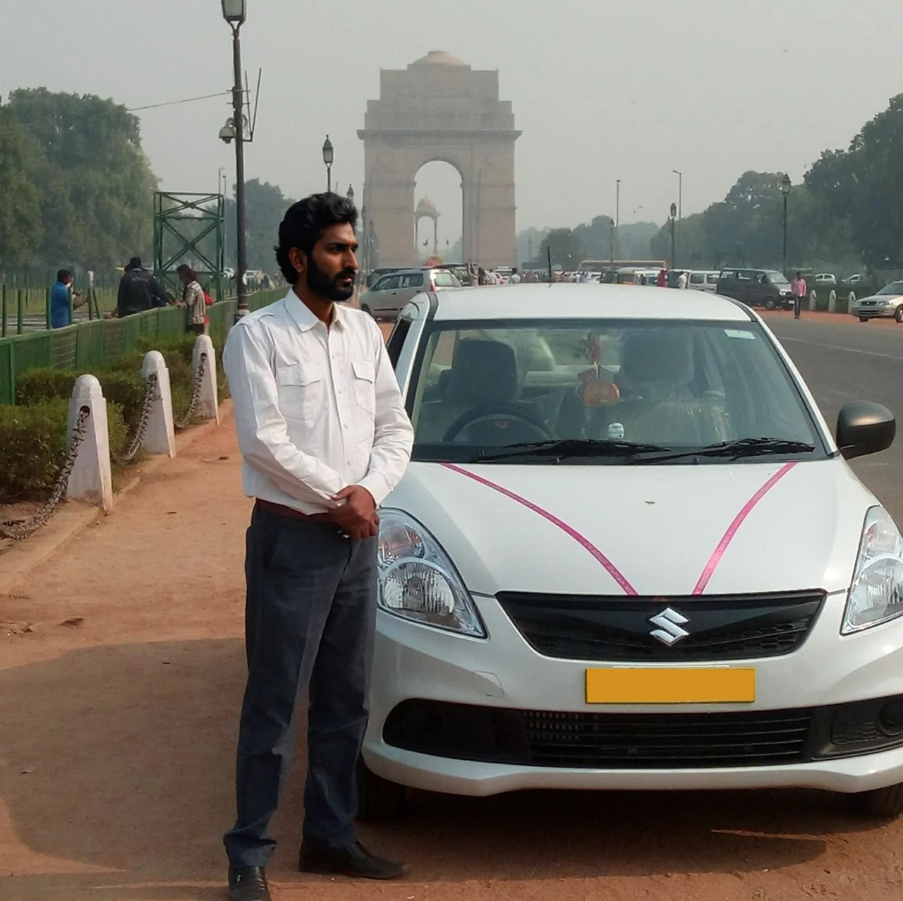White Maruti Suzuki Swift Dzire with a driver, front view