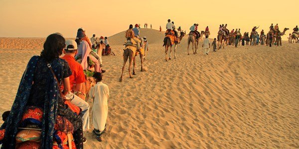 A camel caravan crossing desert dunes near Jaisalmer