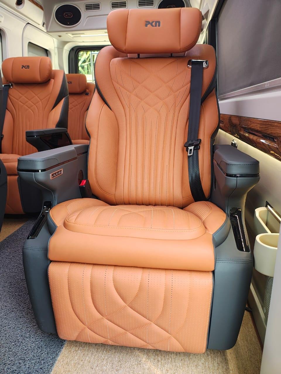 Tan seat with stitched upholstery, armrests and an extended leg rest